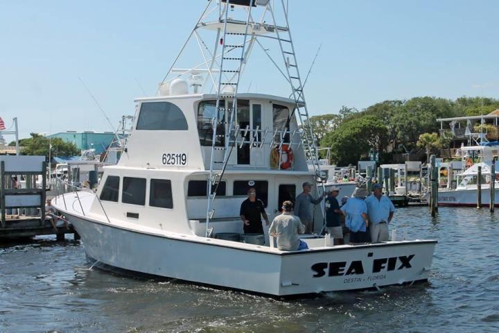 people on parked sea fix boat